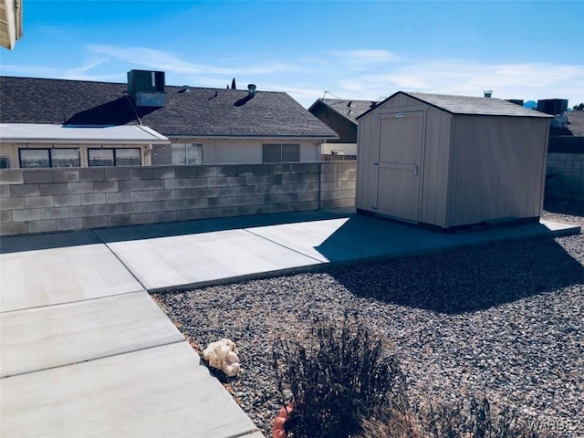 exterior space featuring a shed, fence, and an outbuilding