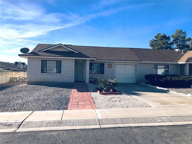 single story home featuring a garage, concrete driveway, brick siding, and a shingled roof