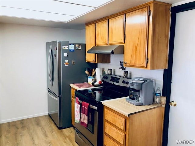 kitchen with stainless steel appliances, brown cabinets, light countertops, and under cabinet range hood