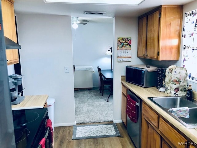 kitchen with visible vents, electric range oven, stainless steel dishwasher, brown cabinetry, and black microwave