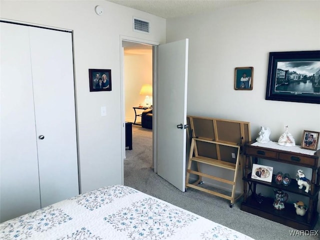 carpeted bedroom with a closet and visible vents