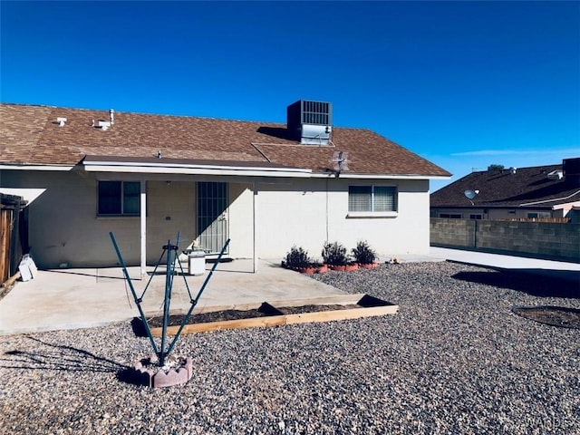 back of house featuring a patio, central AC, fence, roof with shingles, and stucco siding