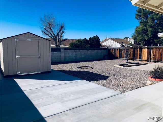 view of yard with a storage shed, a fenced backyard, an outbuilding, and a patio