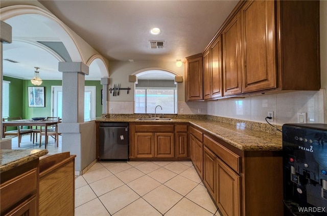 kitchen featuring ornate columns, visible vents, brown cabinetry, and dishwasher