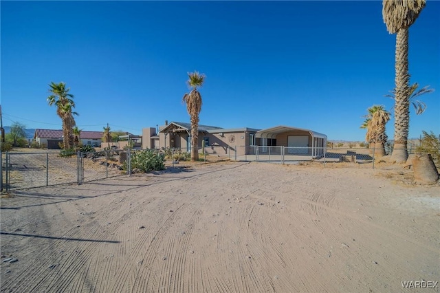 view of front of property featuring driveway, fence, and a carport