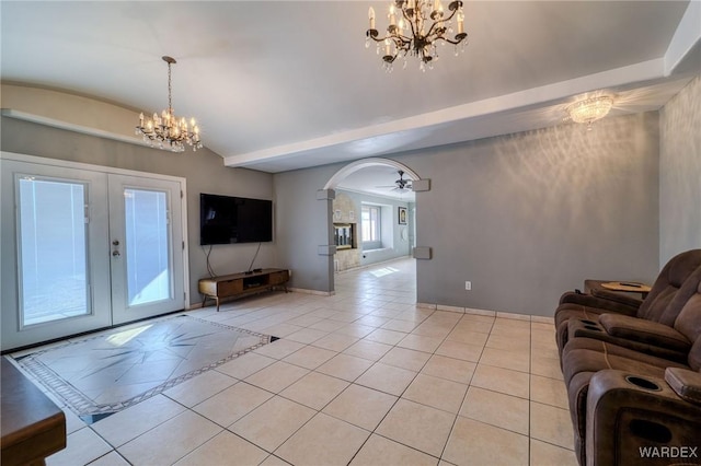 unfurnished living room with light tile patterned floors, arched walkways, lofted ceiling, french doors, and a notable chandelier