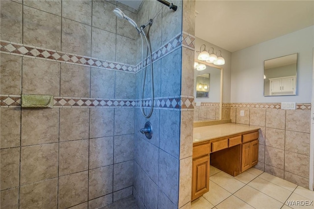 full bathroom featuring tile patterned flooring, tiled shower, tile walls, and vanity