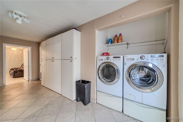 clothes washing area with light tile patterned floors and washing machine and dryer