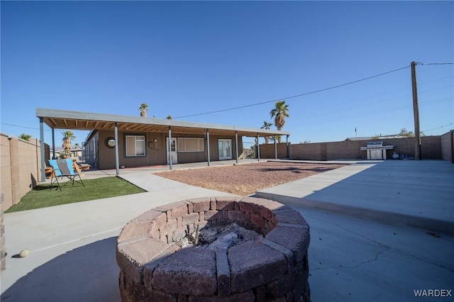 view of front facade featuring an outdoor fire pit, a patio area, and a fenced backyard