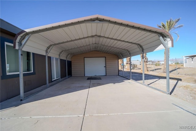 view of car parking with a detached garage and a carport