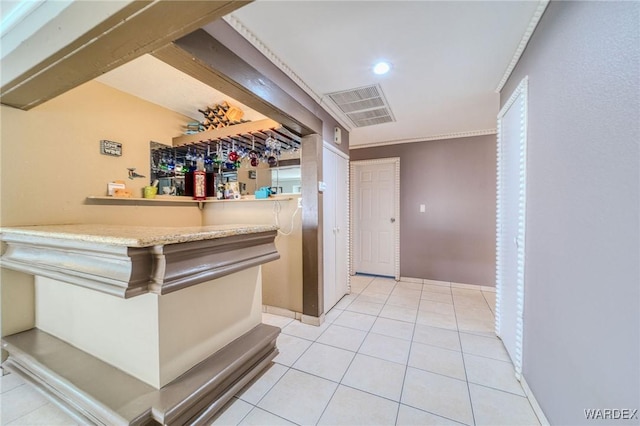 bar with light tile patterned floors, a dry bar, visible vents, and baseboards