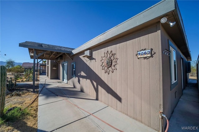 view of property exterior featuring a patio area and a wall mounted air conditioner