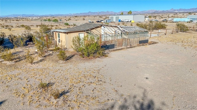 exterior space with a mountain view, an outdoor structure, and fence