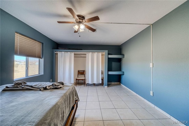 bedroom with ceiling fan, light tile patterned flooring, and baseboards