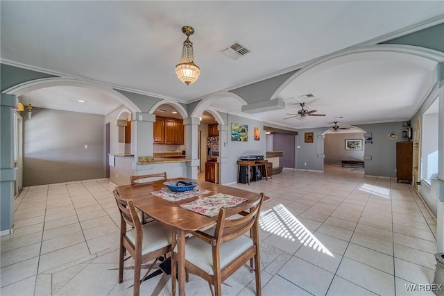 dining room with arched walkways, light tile patterned flooring, visible vents, and a ceiling fan