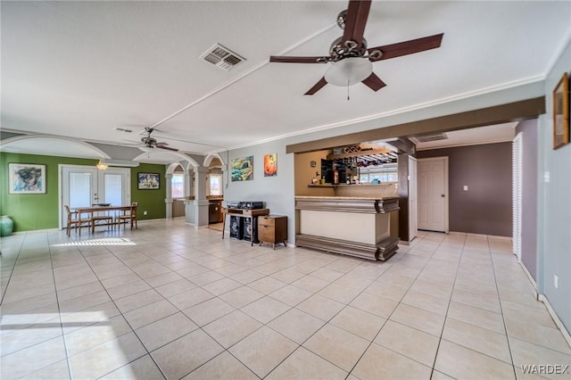 unfurnished living room featuring arched walkways, ceiling fan, light tile patterned flooring, and visible vents