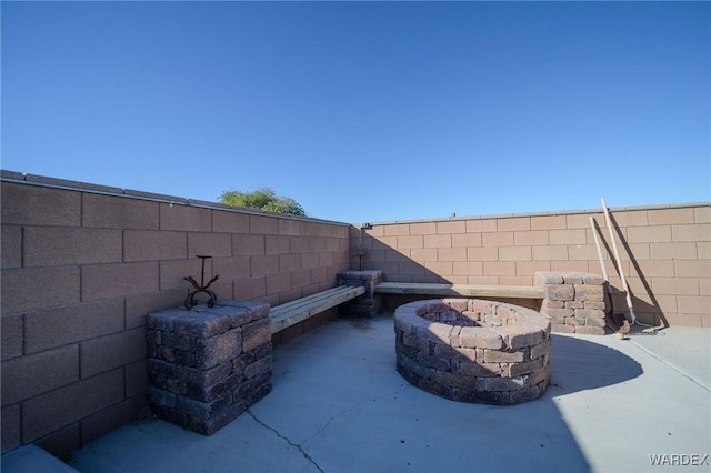 exterior details featuring an outdoor fire pit and a fenced backyard