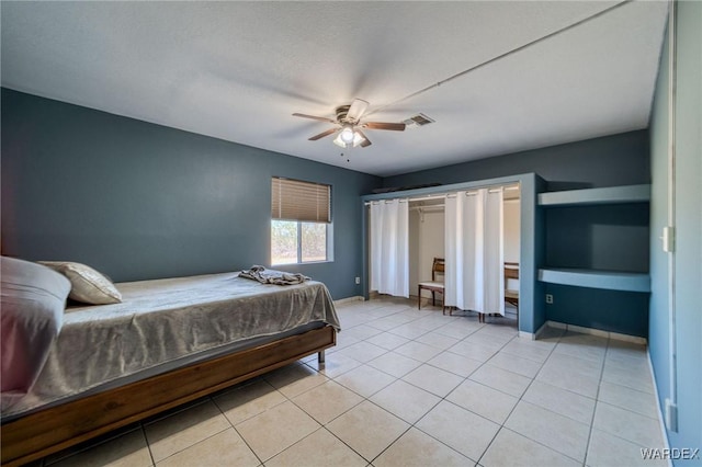 bedroom featuring a ceiling fan, visible vents, baseboards, and light tile patterned floors