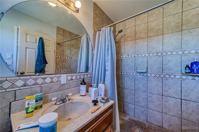 bathroom featuring tasteful backsplash, tiled shower, and vanity