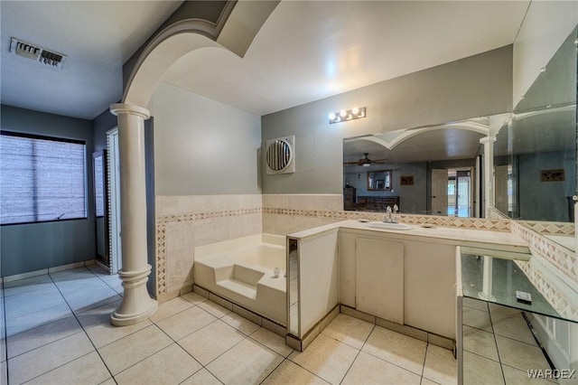 bathroom featuring tile patterned floors, visible vents, vanity, ornate columns, and a bath