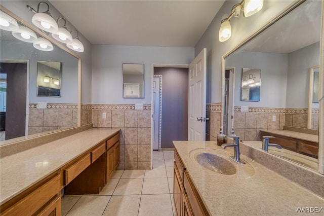 full bathroom with wainscoting, vanity, tile walls, and tile patterned floors