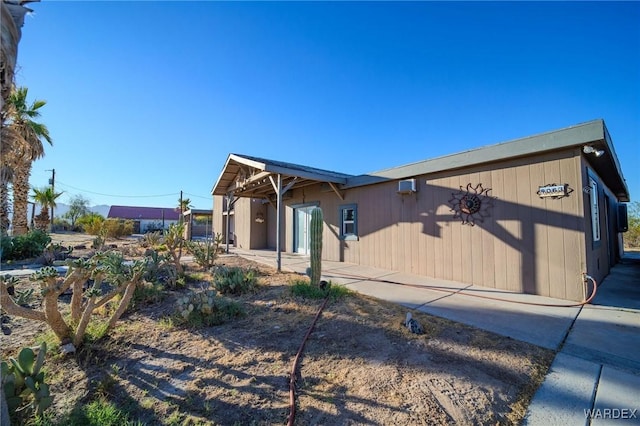 view of front of home featuring a patio and a wall mounted air conditioner