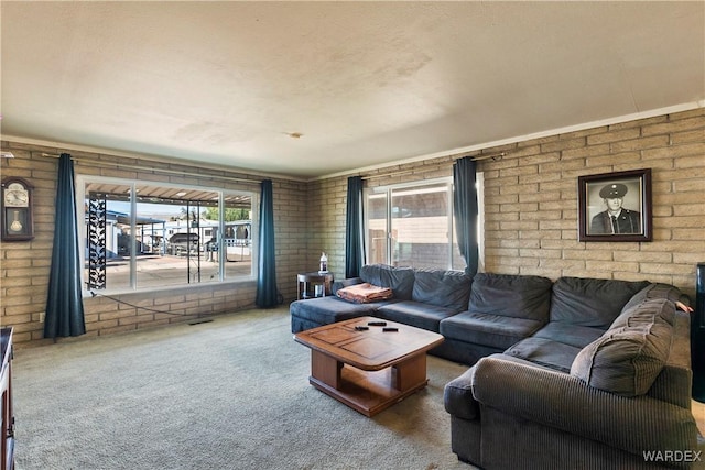 living area with carpet floors and brick wall