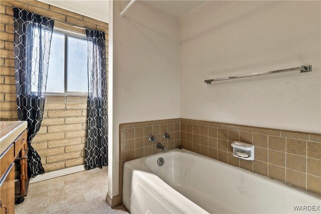 full bathroom featuring a garden tub and vanity