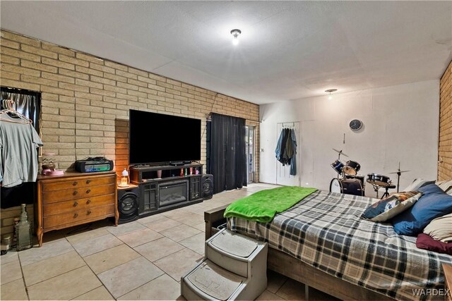 bedroom with light tile patterned floors and brick wall