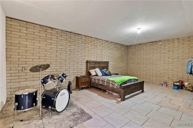 bedroom with light tile patterned floors and brick wall