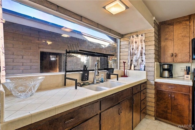 kitchen featuring backsplash, a sink, and tile counters