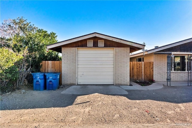 detached garage with driveway and fence