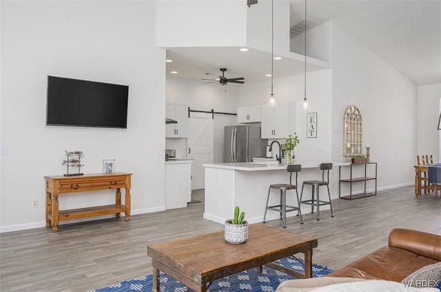 2044 E Los Lagos Dr, Fort Mohave, AZ 86426 - living area with high vaulted ceiling, light wood-style flooring, a ceiling fan, recessed lighting, and a barn door