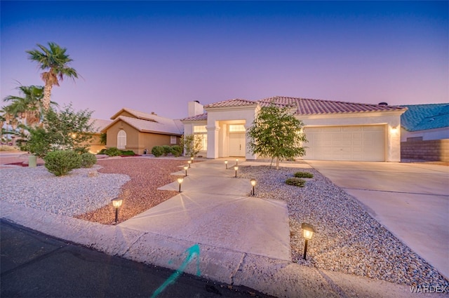 2044 E Los Lagos Dr, Fort Mohave, AZ 86426 - mediterranean / spanish home featuring a tile roof, concrete driveway, stucco siding, and a garage