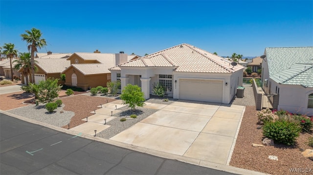 2044 E Los Lagos Dr, Fort Mohave, AZ 86426 - view of front of property with an attached garage, a tiled roof, concrete driveway, stucco siding, and a residential view
