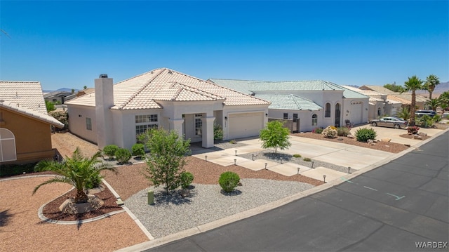 2044 E Los Lagos Dr, Fort Mohave, AZ 86426 - mediterranean / spanish home with driveway, a garage, stucco siding, a tile roof, and a chimney