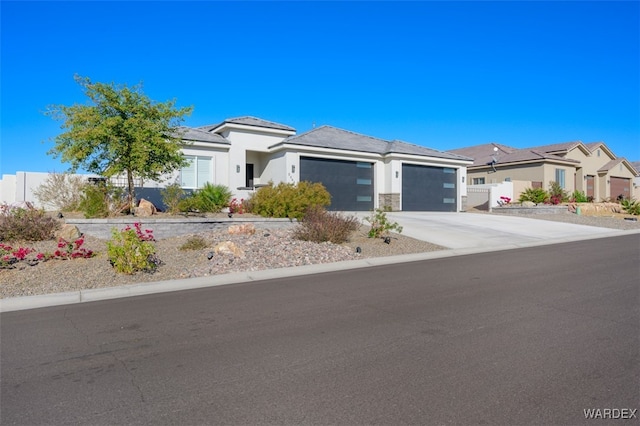 prairie-style home with an attached garage, a residential view, fence, and concrete driveway