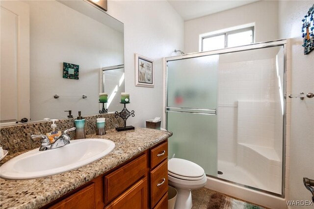 full bath featuring vanity, a shower stall, and toilet