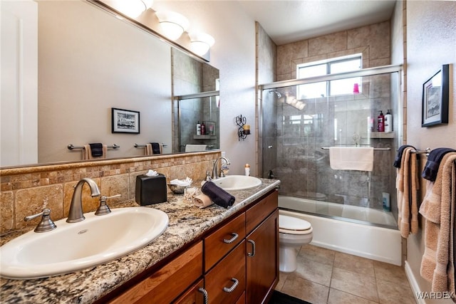 bathroom with toilet, tile patterned flooring, enclosed tub / shower combo, and a sink