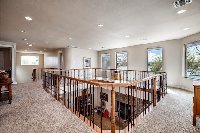 hall with a wealth of natural light, carpet flooring, visible vents, and recessed lighting