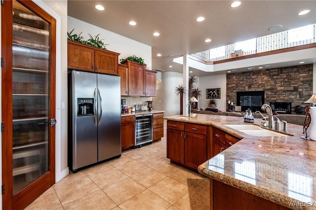 kitchen with wine cooler, open floor plan, light tile patterned flooring, a sink, and stainless steel fridge