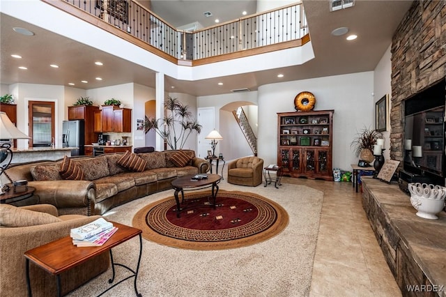 living room featuring arched walkways, visible vents, a towering ceiling, and recessed lighting