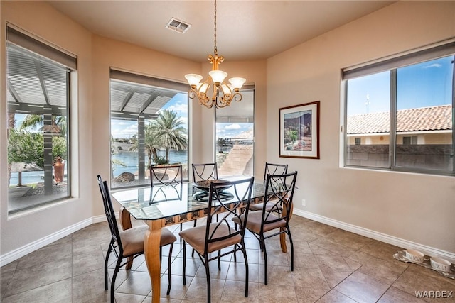 tiled dining room with plenty of natural light, a water view, visible vents, and an inviting chandelier