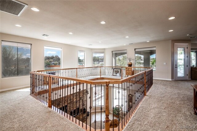 hall featuring a wealth of natural light, recessed lighting, visible vents, and carpet flooring