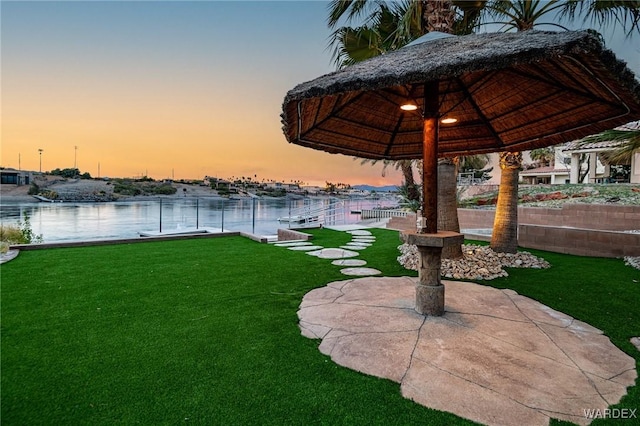 view of yard with a water view, fence, and a gazebo