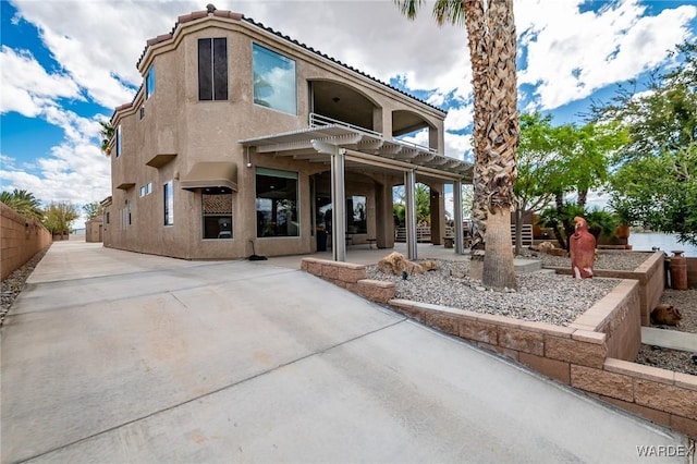 back of property featuring fence, a patio, and stucco siding