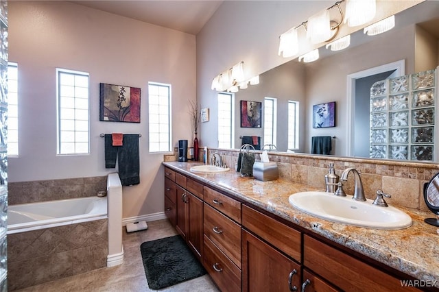 bathroom featuring plenty of natural light, a sink, and a bath