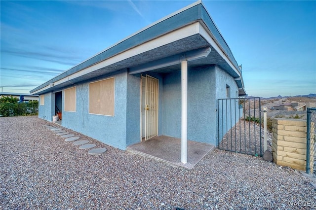 view of home's exterior featuring a gate, fence, and stucco siding