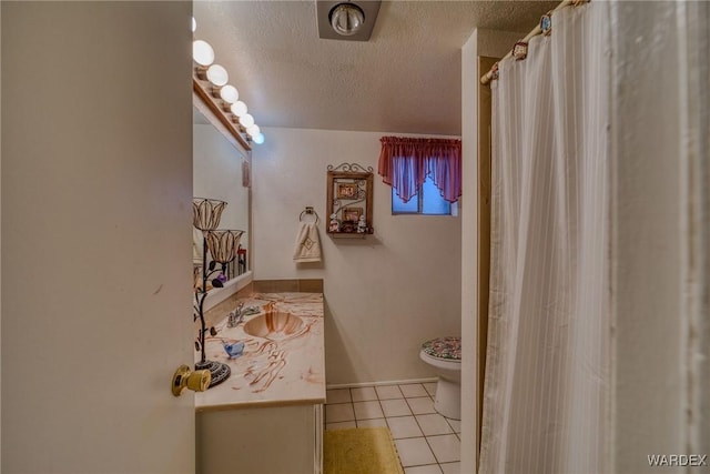 bathroom featuring toilet, vanity, a textured ceiling, a shower with curtain, and tile patterned floors