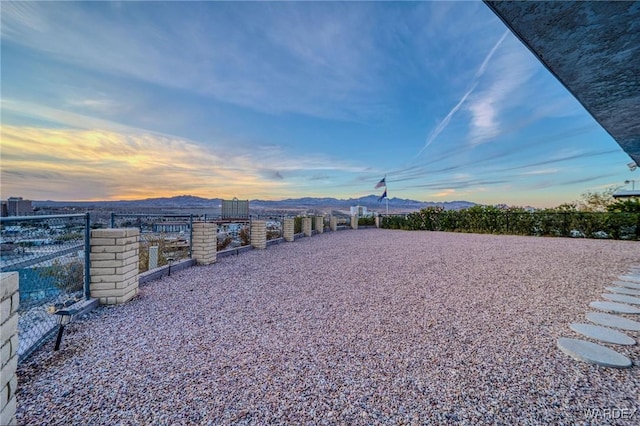 yard at dusk with fence and a mountain view